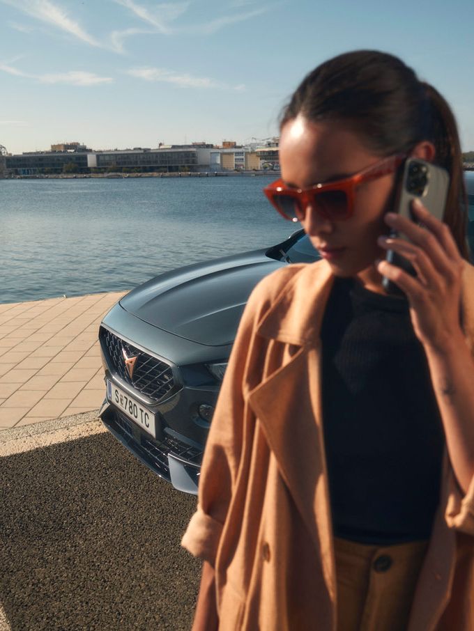 Eine Frau telefoniert vor einem CUPRA Formentor