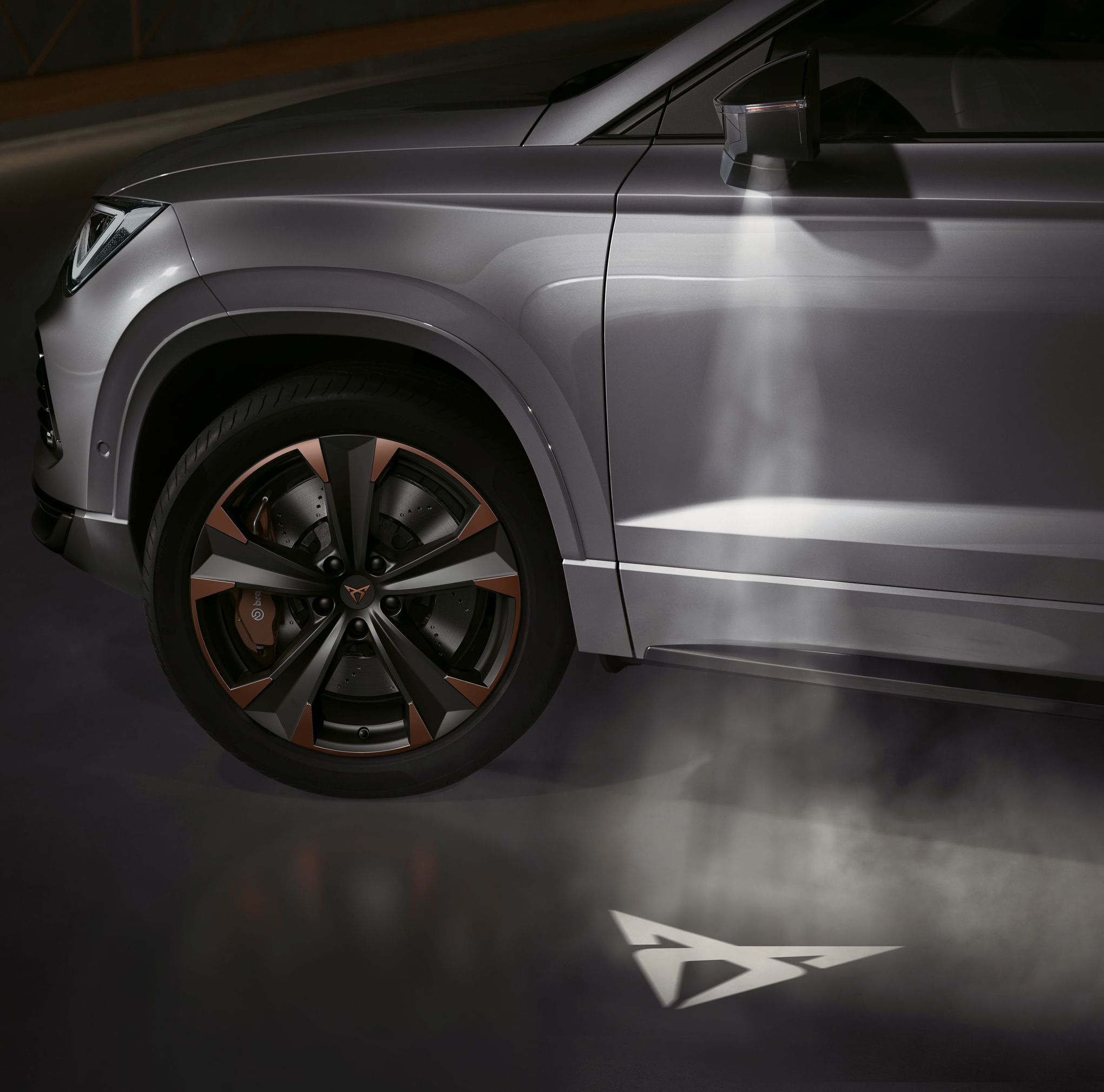 CUPRA Logo, das vom CUPRA Ateca auf den Boden projiziert wird und die Verbindung zur CUPRA Tribe symbolisiert.